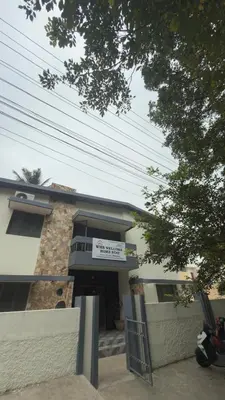 a building with a sign in front of it at Roshan's Welcome Home Stay in Mysore
