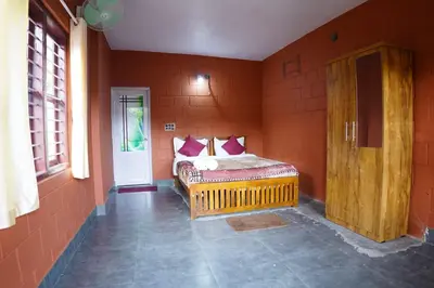 a bedroom with a bed in the corner of a room at Stay with Lakeview Ponnampet in Ponnampet