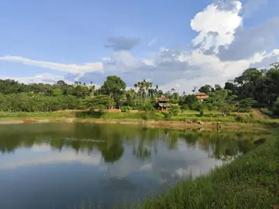 a body of water with trees in the background at Stay with Lakeview Ponnampet in Ponnampet