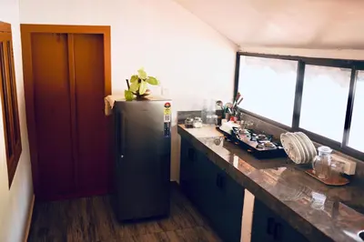 a kitchen with a refrigerator and a counter top at 50 Fables Vintage Kerala Pool Home in Pulpally