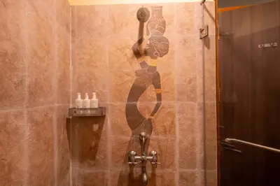 a mural of a woman on the wall of a shower at SaffronStays Valleyfall in Kotagiri