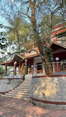a building with stairs and a tree in front of it at Spillway private pool villa in Meenangadi