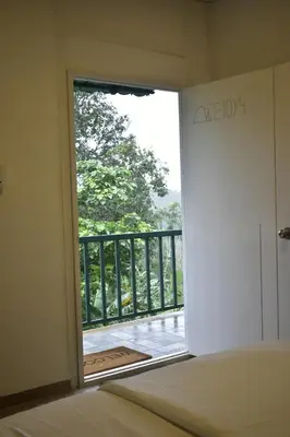 a bedroom with a door open to a balcony at Rays Of Bliss Boutique Resort in Mananthavady