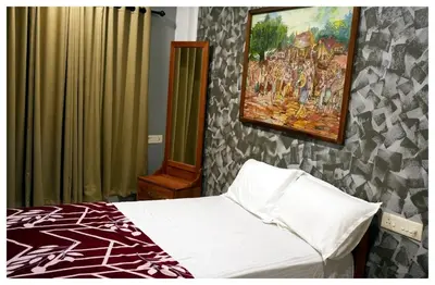a bedroom with a bed and a painting on the wall at Vista Chembra Service Apartment 20A in Meppādi