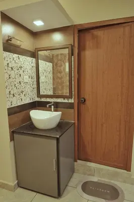 a bathroom with a sink and a wooden door at Vista Chembra Service Apartment 20A in Meppādi