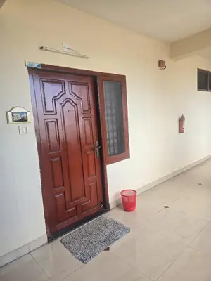 a wooden door in a room with a red bucket at The Western Castle Apartment - 2BHK Apartment in Kannur