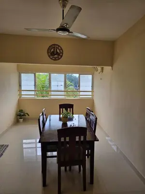 a dining room with a table and chairs and a ceiling fan at The Western Castle Apartment - 2BHK Apartment in Kannur