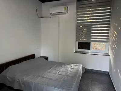 a small bedroom with a bed and a window at Spice garden farm stay in Kodali