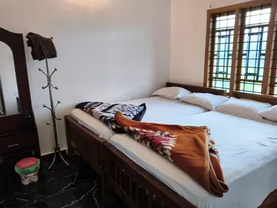 a bedroom with a bed with a blanket on it at Paalm view premium resort in Kanthalloor