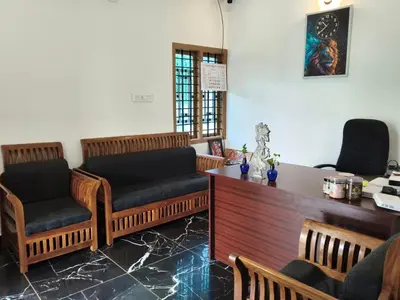 a waiting room with two chairs and a desk at Paalm view premium resort in Kanthalloor