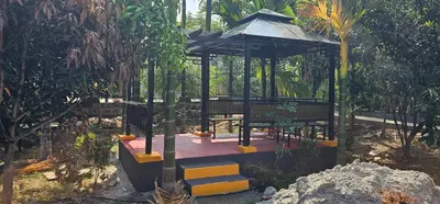 a gazebo in a garden with a tree at Ambience Retreat in Sivasamudram