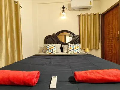 a bedroom with a large bed with two red pillows at shalom 3bhk in Mysore