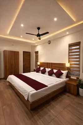 a bedroom with a large bed with a ceiling at Honeymoon Holidays in Vythiri