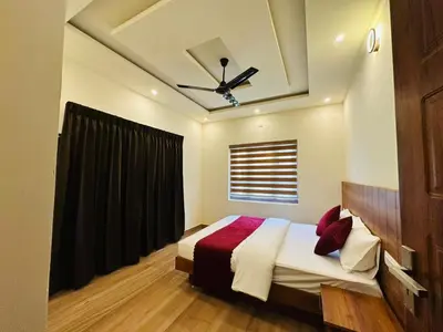 a bedroom with a bed with a ceiling fan at Honeymoon Holidays in Vythiri