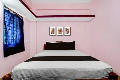 a bedroom with a bed in a room with pink walls at Hotel O Nimishamba Residency in Mysore