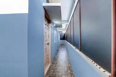 a hallway with blue walls and a tile floor at Hotel O Nimishamba Residency in Mysore