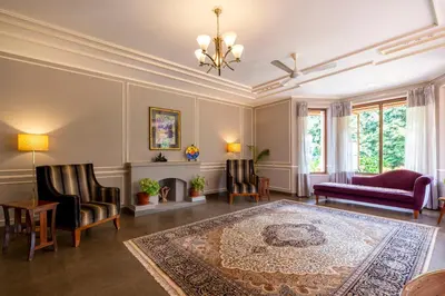 a living room with a couch and chairs and a rug at amã Stays & Trails - Taneerhulla Bungalow, Coorg in Titimati