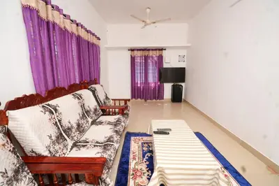 a living room with a couch and purple curtains at Stay Vista in Mananthavady