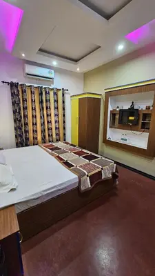 a bedroom with a bed and a large window at Oudh blooms in Shoranūr