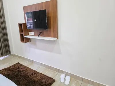 a room with a tv on a white wall at Dreamwagon hotel lakkidi in Vythiri