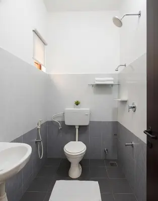 a bathroom with a toilet and a sink at Sai Sadan Residency in Lakkidi