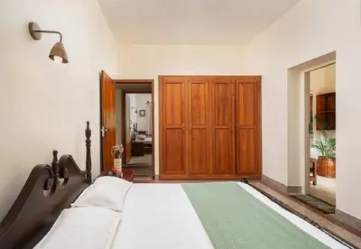 a bedroom with a bed and a wooden cabinet at Enteveedu Homestay in Panamaram