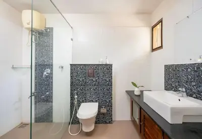 a bathroom with a toilet and a sink and a shower at Enteveedu Homestay in Panamaram