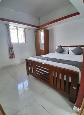 a bedroom with a large bed and a window at Vattavada Homestay in Vattavada