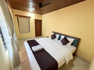 a bedroom with a large bed with white sheets and pillows at VIVIPRA Habitat, Coorg in Madikeri