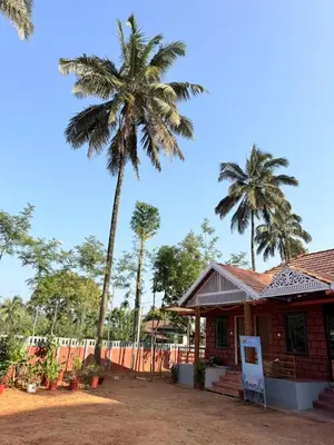 a house with two palm trees in the background at VIVIPRA Habitat, Coorg in Madikeri