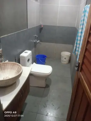a bathroom with a white toilet and a sink at Puthooram Veedu in Kannur