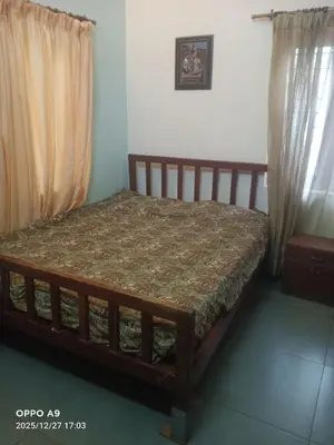 a bed sitting in a room with at Puthooram Veedu in Kannur