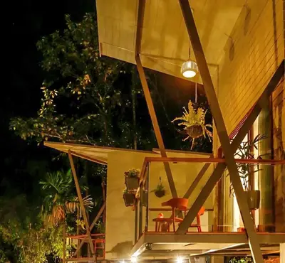a wooden house with a balcony at night at LAKE N DAZE by Masika stays in Ambalavayal