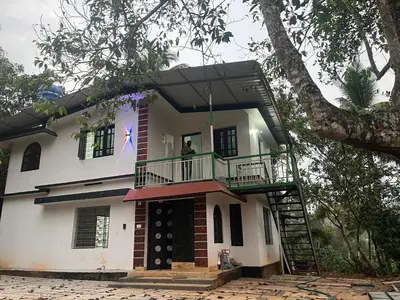a man standing on the balcony of a house at VY3 Homes in Vythiri