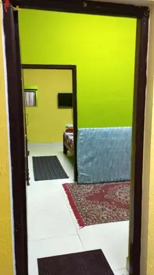 a room with a green wall and a mirror at VR Home Stay Ooty in Ooty