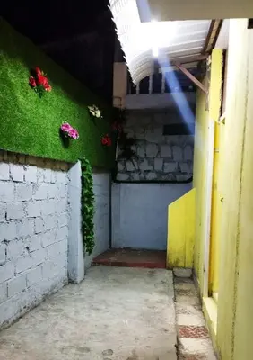 a room with a green wall with flowers on it at VR Home Stay Ooty in Ooty