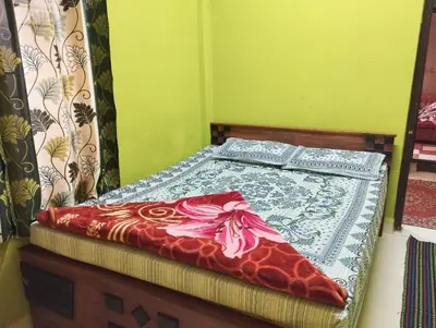 a bed with two pillows on top of it at VR Home Stay Ooty in Ooty