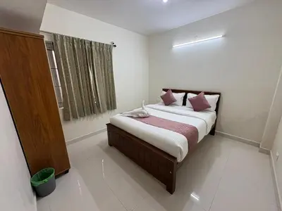 a bedroom with a bed in a room with a window at BBR Residency in Ooty