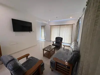 a living room with a couch and a tv at BBR Residency in Ooty