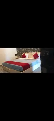 a bedroom with a bed with red pillows at Elephant County Resort in Masinagudi