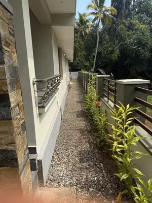 a walkway next to a building with plants at Premium house near Cochin Airport for NRI families in Nedumbassery