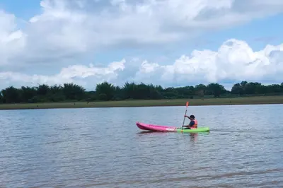 a person sitting on a kayak in the water at Tiger Woods Homestay Kabini in Antarasante