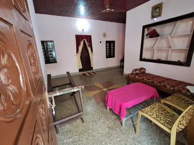 a living room with a pink table and chairs at A-Kutty in Irinjālakuda
