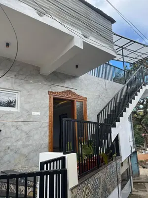 a house with a staircase leading to a door at Village Villa in Vālpārai
