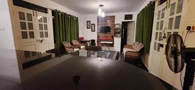 a living room with a large black table and chairs at Kodamukku water front cottage in Trichūr