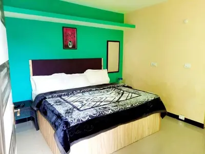 a bedroom with a bed with a green wall at Suriya Residency in Ooty
