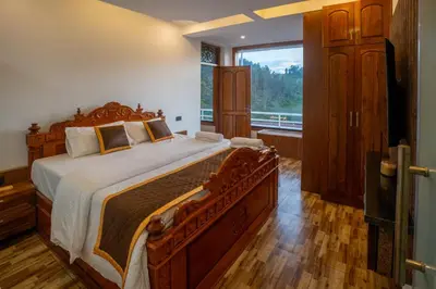a bedroom with a large bed and a large window at Mandarin Orchid Resort in Kotagiri