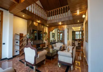 a living room with couches and chairs in a room at Mandarin Orchid Resort in Kotagiri