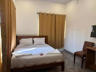 a bedroom with a bed and a chair at Aagneyam villa in Kozhikode