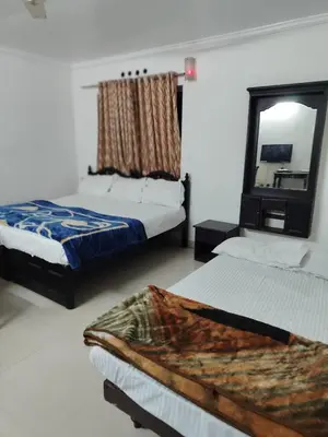 a bedroom with two beds and a mirror at Kurinji home stay munnar in Munnar